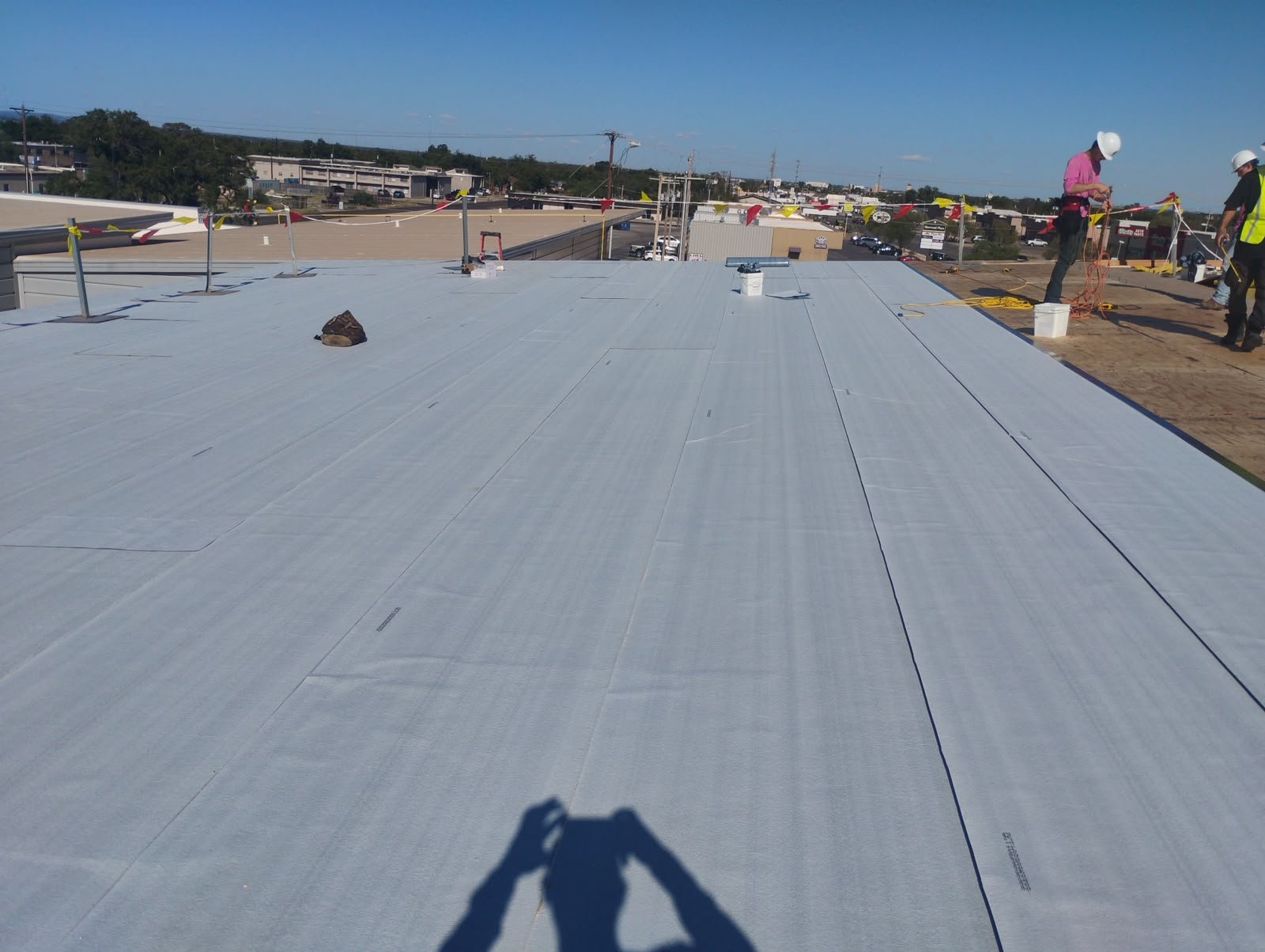 Large commercial roof with single-ply membrane installation in progress