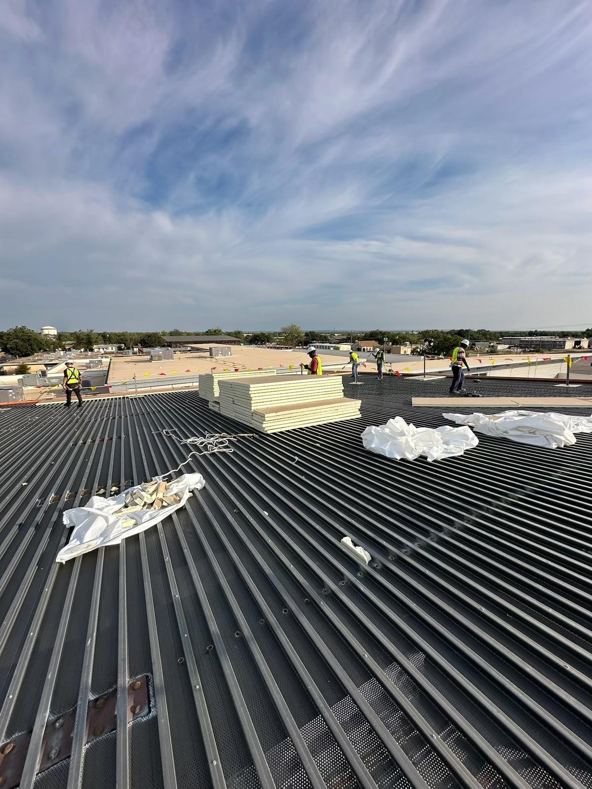 ISO insulation boards staged on a steel roof deck during commercial re-roof